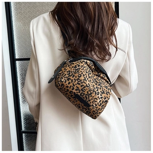 Detailed view of leopard print canvas waist bag worn over a beige blazer by a model
