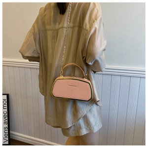 Dettaglio della borsa vintage rosa con cornice in metallo dorato e catena moda