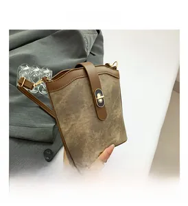 Detail shot of vintage bucket bag with contrast trim and gold-tone twist lock closure