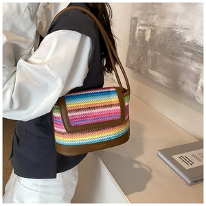 Macro shot of colorful woven texture and brown leather details on the crossbody bag