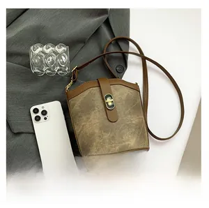Detailed shot of brown bucket bag with vintage gold swivel lock and textured finish