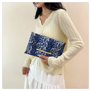 Elegant blue leopard print envelope clutch bag with gold metallic trim and velvet texture