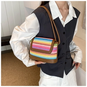 Detailed side view of rainbow woven shoulder bag with brown faux leather straps and trim