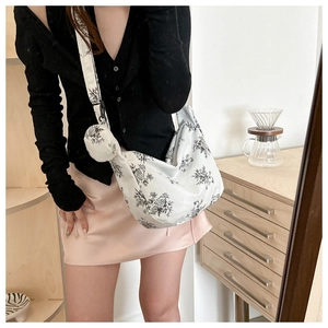 Detailed close-up of corduroy floral crossbody bag with matching round coin purse pouch