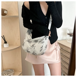 Detail of off-white corduroy crossbody bag with vintage black floral print pattern