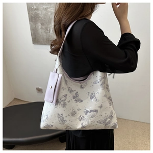 Détail du sac cabas imprimé papillon avec pochette violette suspendue en accessoire