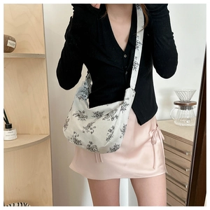 Detail of floral crescent crossbody bag with soft corduroy texture and wide strap