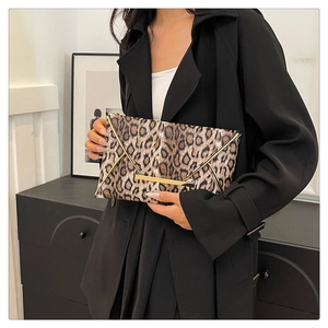 Close-up of leopard print envelope clutch bag with elegant gold metal trim detail