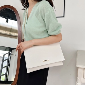 Minimalist white envelope clutch bag with gold chain strap and sleek metal accent