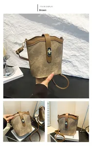 Detail of vintage brown canvas bucket bag showing leather trim and metal twist lock closure