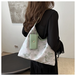 Détail du grand sac cabas en toile à motifs papillons verts avec petite pochette en cuir