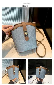 Detail of blue wool bucket bag with brown leather trim and metal twist lock closure