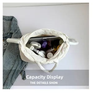 Spacious interior of white quilted puffer tote bag holding a tablet and headphones