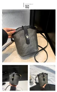 Close-up of a dark grey bucket bag showing the silver oval twist lock and smooth black trim