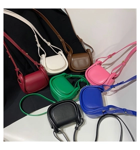 Collection of mini saddle-shaped crossbody bags in seven vibrant faux leather colors
