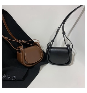 Detail of vintage mini saddle bags in brown and black leather with adjustable straps