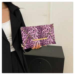 Close-up of pink leopard print envelope clutch bag with gold metallic edge accents
