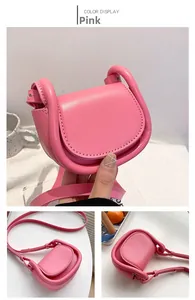 Detailed view of pink mini saddle bag with top handle and adjustable shoulder strap