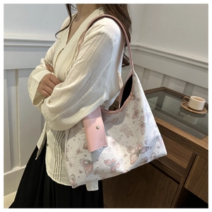 Détail du sac cabas blanc avec motifs papillons roses et petite pochette assortie
