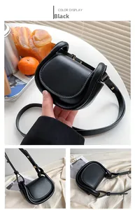 Detail of a black mini saddle bag for kids with adjustable strap and gold metal hardware