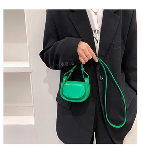Fashionable bright green mini crossbody bag styled with a modern black oversized blazer