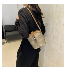 Close-up of a retro contrast color bucket bag with metal lock shown on a model
