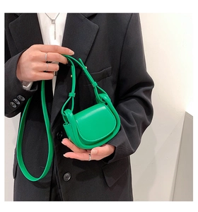Detail of neon green leather micro crossbody bag with saddle flap and shoulder strap