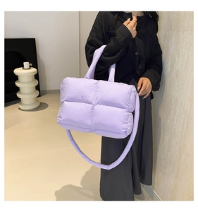 Detail of light purple quilted puffer tote bag featuring a padded shoulder strap and soft texture