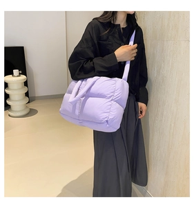 Detail of purple quilted down tote bag showing puffy texture and versatile shoulder straps
