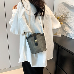 Vintage grey suede bucket bag with black leather trim and gold twist lock closure on a model