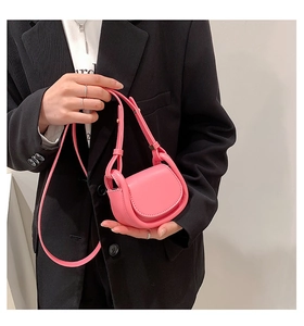 Pink mini crossbody bag for kids featuring a semi-circle flap and adjustable leather strap