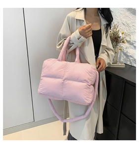 Detail of light pink quilted tote bag with padded texture and wide shoulder strap