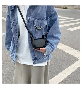 Classic black matte leather saddle bag for kids shown in an outdoor street style outfit
