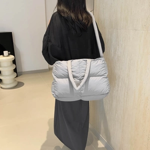 Light gray padded nylon tote bag for women showing a stylish quilted puffer design and strap