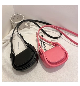 Detail view of mini retro saddle bags in black and pink on white textured fabric