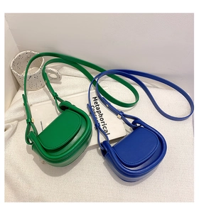 Close-up of vibrant blue and green mini PU leather saddle bags with thick rolled piping