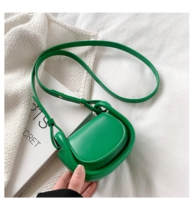 Close-up of grass green semi-circle mini crossbody bag with smooth leather finish