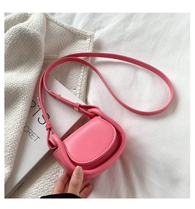 Detail of pink leather crossbody bag with U-shape design and adjustable shoulder strap