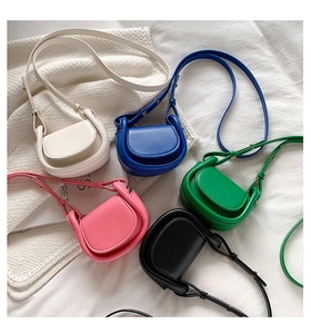 Flat lay of colorful mini saddle bags in white, navy, green, pink and black finishes