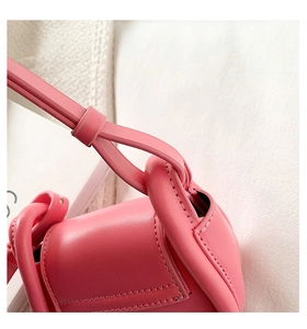 Close-up of pink leather handbag showing detailed stitching and rounded edges