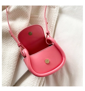 Detail of pink faux leather kids saddle bag with magnetic buckle and adjustable strap