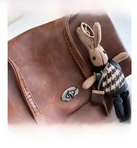 Close-up of vintage brown leather tote bag with silver twist lock and bunny pendant