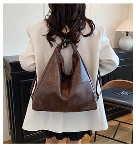 Bolso de hombro vintage marrón oscuro mostrado en modelo como referencia de tamaño