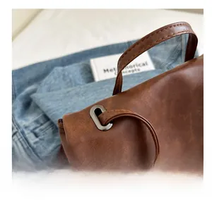 Close-up of vintage brown leather bag detail with durable metal buckles and fine texture