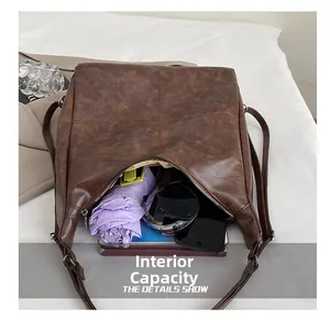 Detalle de gran capacidad del bolso tote retro marrón con paraguas y tablet incluídos