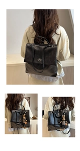 Detail of black matte leather backpack featuring a vintage twist lock and plaid rabbit charm