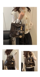 Macro detail of vintage brown leather backpack with silver turn-lock and cute rabbit pendant