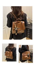 Detail view of vintage dark brown faux leather backpack with metallic twist lock and rabbit charm