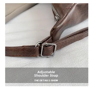 Detalle de correa ajustable con hebilla plateada en bolso hobo de cuero marrón oscuro