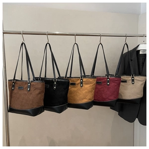 Multiple colors of large tote bags with diamond stitching on display racks